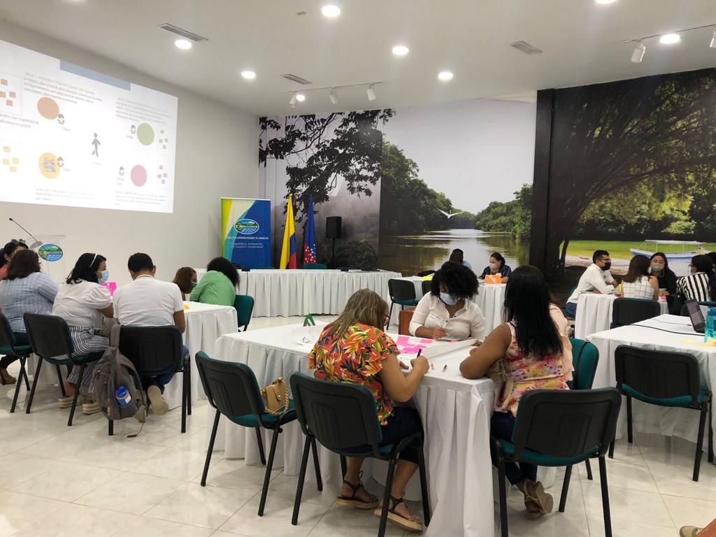 Docentes en mesa de trabajo en auditorio de corpamag durante taller